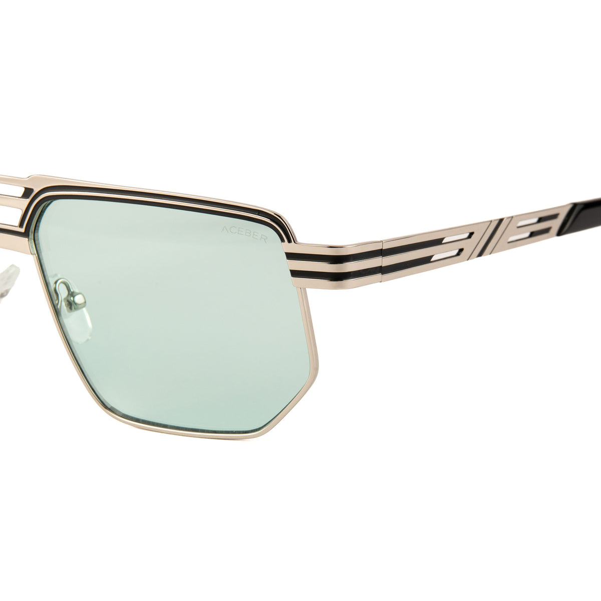 Silueta aviator geometrica, cu forma hexagonala indrazneata si linii duble gravate pe rama — un design masculin, arhitectural, facut sa impuna prezenta. Rama argintie, cu striatii negre paralele care traverseaza atat fruntea cat si bratele, un detaliu grafic distinctiv. Brate din havana texturata, contrast elegant fata de rama metalica.